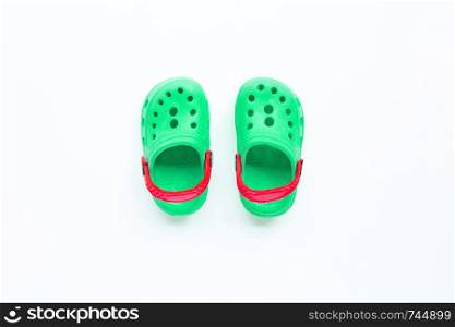 Green children's rubber sandals on white background. Top view