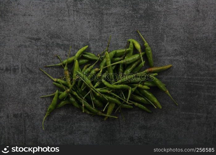 green Chili pepper on dark rock background