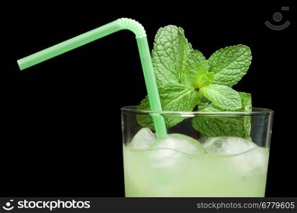 Green cocktail with cubes ice. Close up glass and mint leaves