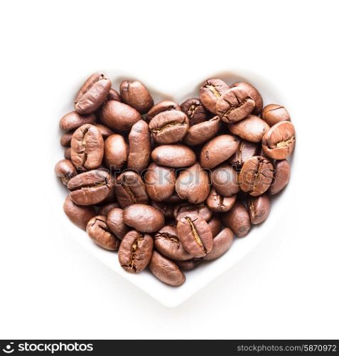 Green coffee beans in the heart shape bowl on a white. green coffee heart