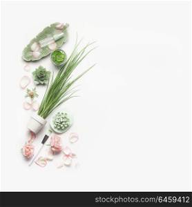 Green cosmetic setting for facial skin care with pink roses on white background, top view, place for text. Beauty and nature herbal cosmetic concept