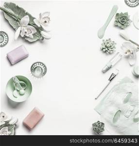 Green Cosmetic setting for facial skin care with white orchid flowers, tools , sheet mask and accessories on white background, top view, place for text, frame Beauty and nature herbal cosmetic concept