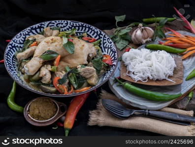 Green curry with Chicken and Green-white varieties of Thai eggplants (Kaeng khiao wan) in Ceramic bowl served with Thai rice noodles (Fermented rice flour noodles). Authentic thai food, Selective focus.