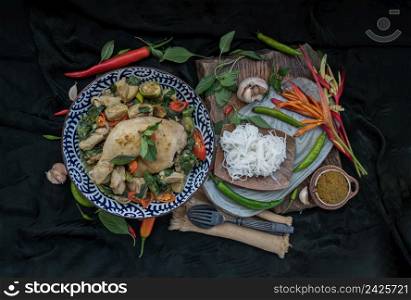 Green curry with Chicken and Green-white varieties of Thai eggplants (Kaeng khiao wan) in Ceramic bowl served with Thai rice noodles (Fermented rice flour noodles). Authentic thai food, Top view, Selective focus.