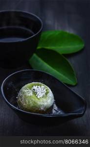 Green Daifuku Mochi Japanese dessert on dish served with hot tea , still life