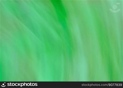 Green defocused dynamic abstract background. Long time exposure motion blur. Green blurred bokeh background with motion effect.