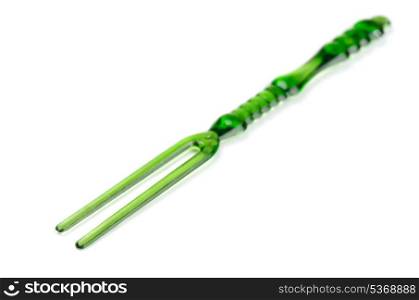 Green disposable plastic cocktail fork isolated on white
