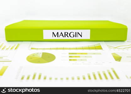 Green document binder with MARGIN word place on graphs analysis and financial reports