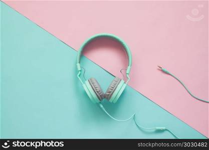 Green earphones on pink and green colors background, Pastel colo. Green earphones on pink and green colors background, Pastel color concept