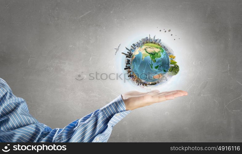 Green Earth planet in palm. Close up of human hands holding Earth planet. Elements of this image are furnished by NASA