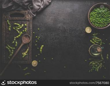 Green Edamame soybeans and green peas on dark rustic background. Healthy food cooking concept. Top view