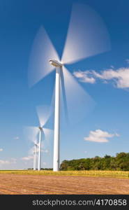 Green Energy Wind Turbines In Field of Sunflowers