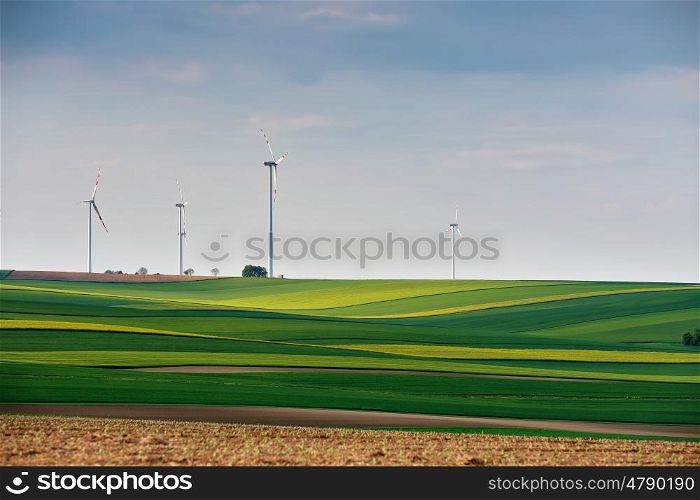 Green environment. Eco power. Wind turbines generating electricity. Spring sunny day on green field with wind power generators in Austria