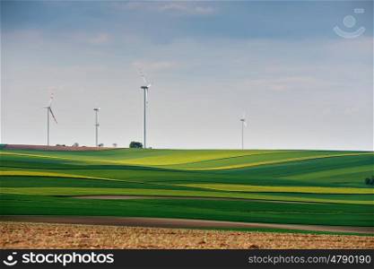 Green environment. Eco power. Wind turbines generating electricity. Spring sunny day on green field with wind power generators in Austria
