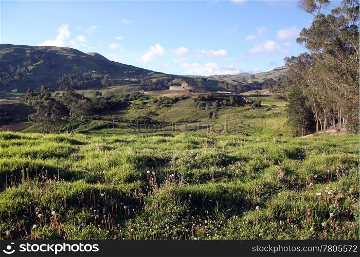 Green field and ruins of fortress in Ingapirca in Ecuador