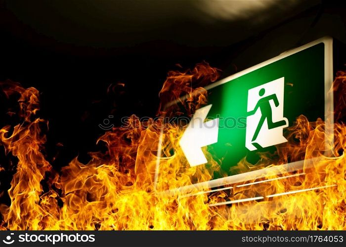 Green fire escape sign hang on the ceiling in the Warehouse. The concept of fire escape training and preparation for evacuation