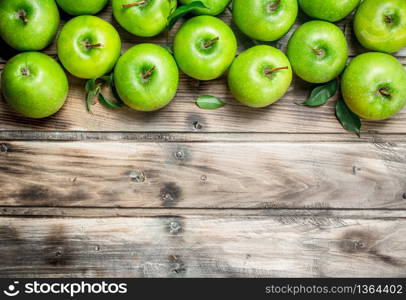 Green fresh apples with leaves. On grey wooden background.. Green fresh apples with leaves.