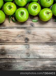 Green fresh apples with leaves. On grey wooden background.. Green fresh apples with leaves.