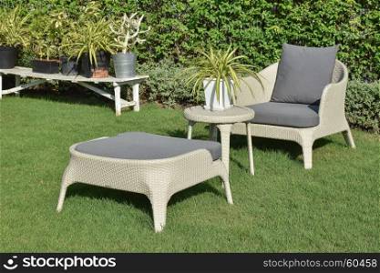 green garden with an outdoor furniture lounge group with rattan chairs, sofa and table