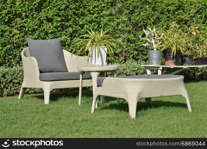 green garden with an outdoor furniture lounge group with rattan chairs, sofa and table
