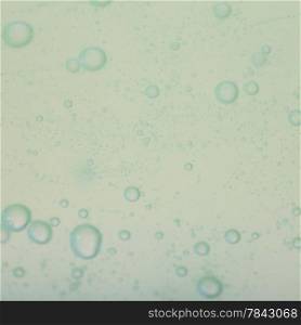 Green gray abstract blurred liquid background with soap bubbles. Square format