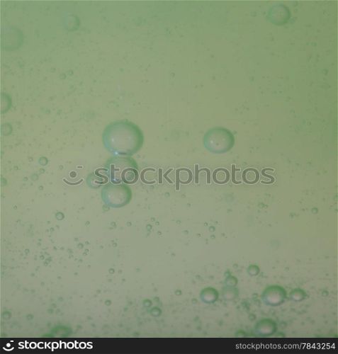Green gray abstract blurred liquid background with soap bubbles. Square format