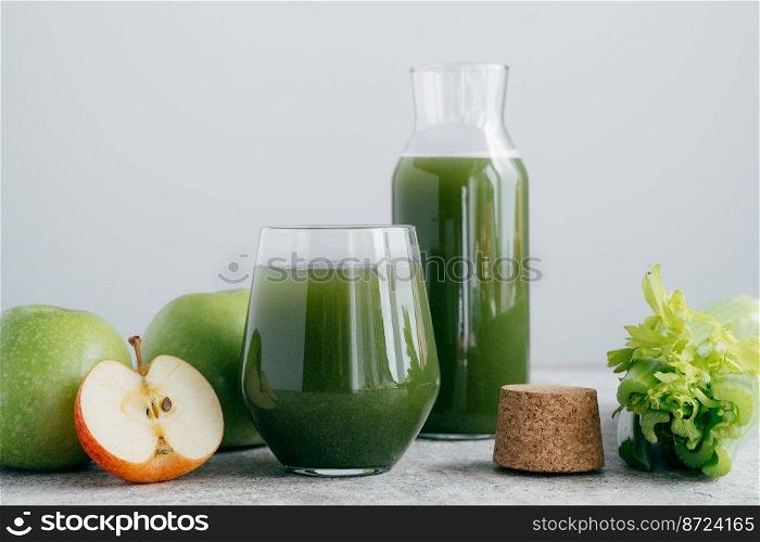 Green healthy celery and apple juice in glassware. Vegetable drink. Fresh smoothie isolated over white background. Organic beverage