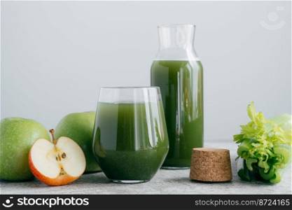 Green healthy celery and apple juice in glassware. Vegetable drink. Fresh smoothie isolated over white background. Organic beverage