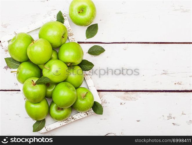 Green healthy organic apples in vintage box on wood background