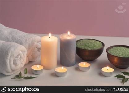 green herbal bath salt towels with illuminated candles white table