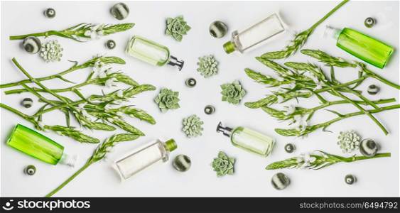 Green herbal vegan natural cosmetic setting with bottles of skin care products with branding copy space, herbs and flowers on white background , top view, flat lay. Beauty concept