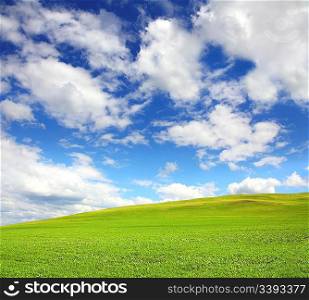 green hill with grass under cloudy sky
