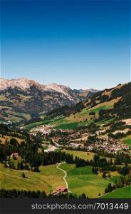 Green hills valley Sorenberg town at foot of mount Brienzer Rothorn with mount Schrattenfluh in background. Switzerland