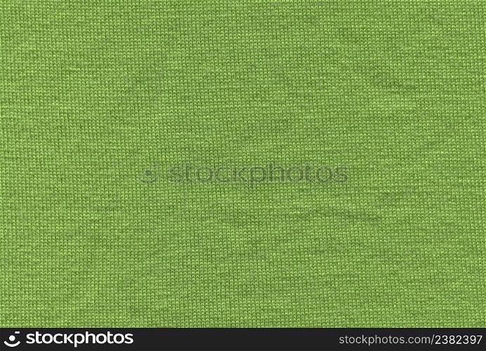 Green knitting wool texture full frame. Knitted green texture surface close up. Textile green material with wicker pattern. Background from softness green merino blanket wool texture