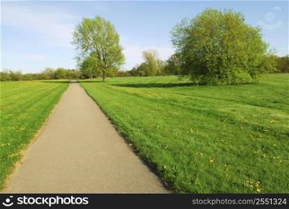 Green late spring landscape with empty recreational trail