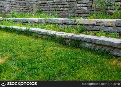 green lawn and stone path with stone walls