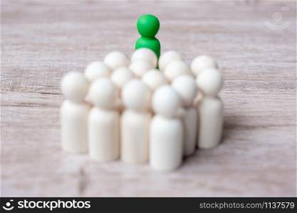 Green leader businessman with crowd of wooden men. leadership, business, team, teamwork and Human resource management concept
