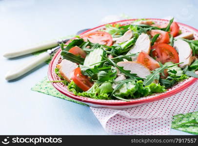 Green leaf salad with vegetables and chicken, close up, selective focus