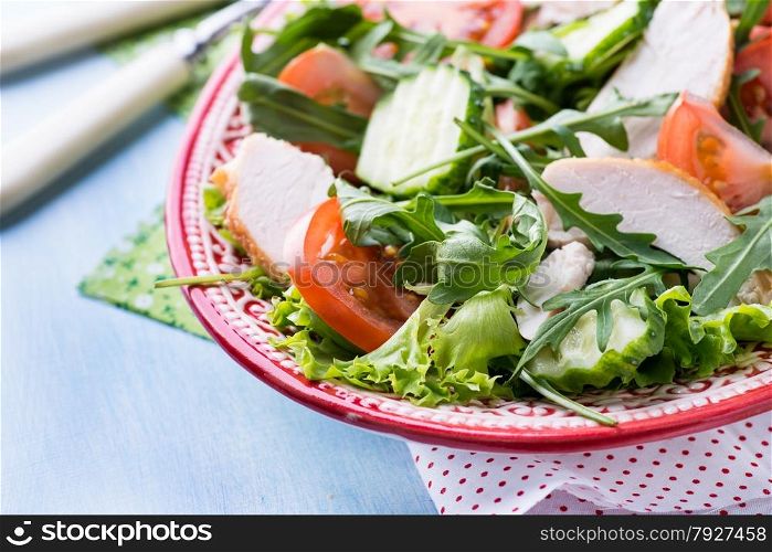 Green leaf salad with vegetables and chicken, closeup, selective focus