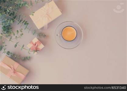 Green leaves with gift boxes with coffee on blue table from above with copy space, flat lay scene, retro toned. Gift boxes with green leaves. Gift boxes with green leaves