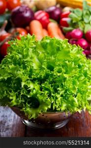 green lettuce salad in colander with fresh vegetables