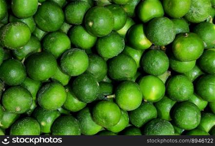 Green lime fruit pile background. Top view.