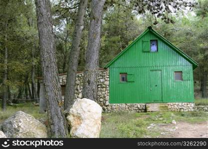 Green little wooden house in a Mediterranean forest