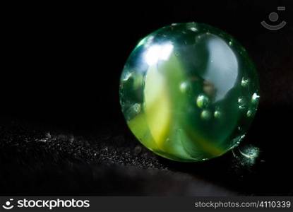 Green marble on black background
