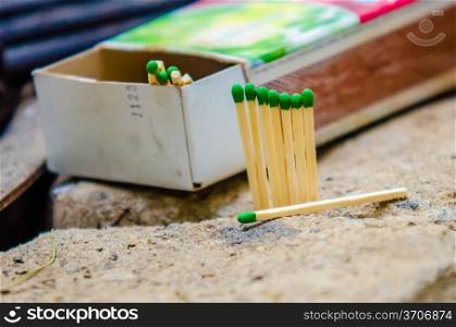 green matches with a box of matches at camping site