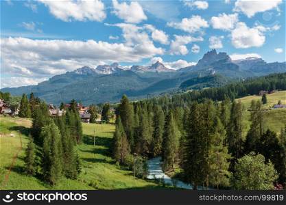 Green Meadow and Typical Houses among Mountains Scenery in Summer Time