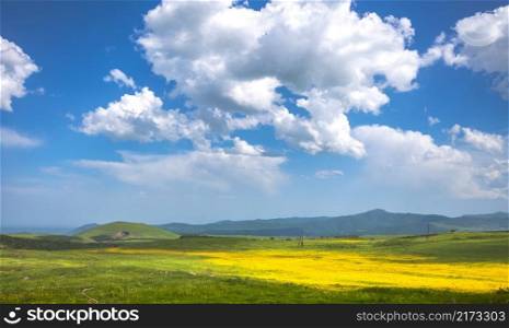 Green meadow, hills and blue sky with clouds. Exploring Armenia.  meadow, hills and blue sky
