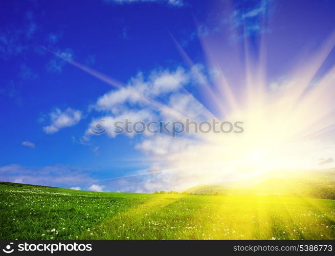 Green meadows and blue sky with sunshine. Nature background