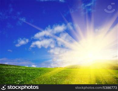 Green meadows and blue sky with sunshine. Nature background