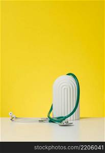 green medical stethoscope on yellow background, copy space
